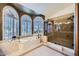 Spa bathroom with a soaking tub, walk-in shower, and white shuttered windows at 6925 W Tonto Dr, Glendale, AZ 85308