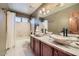 Bathroom featuring a vanity with double vessel sinks, granite counters, and a tub/shower combo at 6925 W Tonto Dr, Glendale, AZ 85308