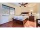 Cozy bedroom features wood floors, a window with blinds, and a ceiling fan at 6925 W Tonto Dr, Glendale, AZ 85308