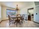 Dining room with a chandelier, table set for six, and a window offering backyard views at 6925 W Tonto Dr, Glendale, AZ 85308