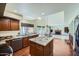 Spacious kitchen featuring granite countertops, an island, and views of the adjacent dining and living areas at 6925 W Tonto Dr, Glendale, AZ 85308