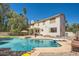 Expansive backyard pool with diving board, patio, and lush landscaping creates an outdoor oasis at 6925 W Tonto Dr, Glendale, AZ 85308