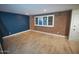 Bright living room with wood floors, exposed brick accents, and a large window at 6961 E Osborn Rd # B, Scottsdale, AZ 85251