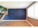 Stylish living area featuring wood flooring, a staircase, and a statement wall at 6961 E Osborn Rd # B, Scottsdale, AZ 85251