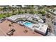 Aerial shot of a community pool surrounded by lounge chairs, palm trees, and white-roofed buildings at 7930 E Camelback Rd # 409, Scottsdale, AZ 85251