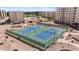 Aerial view of two well-maintained tennis courts with surrounding landscaping and beige apartment buildings at 7930 E Camelback Rd # 409, Scottsdale, AZ 85251