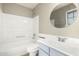 Bathroom with tub/shower combo, integrated sink and vanity, and round mirror at 8014 W Mescal St, Peoria, AZ 85345