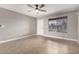 Well-lit living room with tile flooring, ceiling fan, and a large window with natural light at 8014 W Mescal St, Peoria, AZ 85345