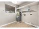Functional utility room with water heater, laundry hookups, and storage shelving for added convenience at 8014 W Mescal St, Peoria, AZ 85345