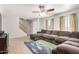 Bright living room with large sectional sofa, ceiling fan, stairs, tile flooring, and natural light at 8226 N 32Nd Dr, Phoenix, AZ 85051