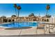Community pool surrounded by wrought iron fencing and desert landscaping, complete with a metal table and chairs at 8226 N 32Nd Dr, Phoenix, AZ 85051