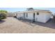 Backyard view featuring a white brick home exterior, screen room, rock groundcover and metal railing at 8320 E Nido Ave, Mesa, AZ 85209