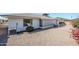 Exterior shot showcasing the home's white brick facade, sunroom, well maintained gravel and landscaping at 8320 E Nido Ave, Mesa, AZ 85209
