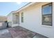 Rear exterior featuring a white brick facade, screen door access to sunroom, and gravel landscaping at 8320 E Nido Ave, Mesa, AZ 85209