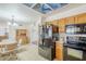 Eat-in kitchen with black appliances, wood cabinetry, and a view to the dining and living areas at 8320 E Nido Ave, Mesa, AZ 85209