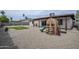 Backyard with gravel, patio, playset, and grass with desert landscaping and block fence at 903 W Barrow Dr, Chandler, AZ 85225