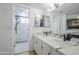 Bathroom featuring marble counters, double sinks, modern fixtures, and a shower at 903 W Barrow Dr, Chandler, AZ 85225