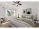 This bright bedroom features a comfy bed with neutral-toned decor and a ceiling fan at 907 W Laguna Dr, Tempe, AZ 85282