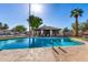 Beautiful community pool with a brick cabana area surrounded by green grass and palm trees at 907 W Laguna Dr, Tempe, AZ 85282