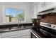 Bright kitchen area with stainless appliances, granite counters, and a view from the window at 907 W Laguna Dr, Tempe, AZ 85282
