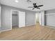 Spacious bedroom with wood-look floors, ceiling fan, and closet access at 9230 N 82Nd Ln, Peoria, AZ 85345