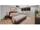 Comfortable bedroom featuring a ceiling fan, wooden floors, and soft, neutral bedding at 9230 N 82Nd Ln, Peoria, AZ 85345