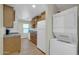 This kitchen features marble countertops, wooden cabinets, a stainless steel refrigerator, and a washer and dryer at 9230 N 82Nd Ln, Peoria, AZ 85345