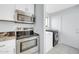 This home features a kitchen with a stainless steel oven and microwave and a nearby washer and dryer at 9230 N 82Nd Ln, Peoria, AZ 85345