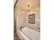 Luxurious bathroom showcasing a soaking tub, chandelier, and ornate wall details at 10365 E Paradise Dr, Scottsdale, AZ 85260