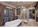 Elegant bathroom features a freestanding tub, glass shower, and access to the outside at 10365 E Paradise Dr, Scottsdale, AZ 85260