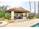 Outdoor covered cabana with stone columns, travertine floor and comfortable seating area at 10365 E Paradise Dr, Scottsdale, AZ 85260