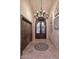 Grand foyer featuring stone floors, an ornate chandelier, and decorative archway stone wall hangings at 10365 E Paradise Dr, Scottsdale, AZ 85260