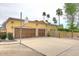 Large three-car garage with wooden doors and an expansive driveway at 10365 E Paradise Dr, Scottsdale, AZ 85260