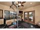 Home gym featuring various exercise equipment, a TV, and double doors to the backyard at 10365 E Paradise Dr, Scottsdale, AZ 85260