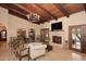 Elegant living room boasts wood-beamed ceilings, travertine floors, a fireplace, and custom lighting at 10365 E Paradise Dr, Scottsdale, AZ 85260