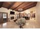 Inviting living room opens to kitchen with a fireplace, beamed ceilings, and travertine tile flooring at 10365 E Paradise Dr, Scottsdale, AZ 85260