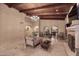 Living room with wooden beam ceiling, travertine tile flooring, fireplace and cozy, neutral furniture at 10365 E Paradise Dr, Scottsdale, AZ 85260