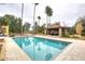 Inviting pool with travertine tile, an open cabana and tall palm trees create a backyard oasis at 10365 E Paradise Dr, Scottsdale, AZ 85260