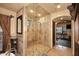 Open concept, walk-in shower room with stone walls and tile flooring at 10365 E Paradise Dr, Scottsdale, AZ 85260