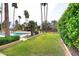 A view of the lush grassy backyard featuring a pool, cabana and mature trees at 10365 E Paradise Dr, Scottsdale, AZ 85260
