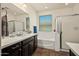 Well-lit bathroom with a dual-sink vanity, a soaking tub, and a glass-enclosed shower at 10635 W Eucalyptus Rd, Peoria, AZ 85383