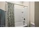 Modern bathroom with white-tiled shower/tub combo and neutral patterned curtain at 10635 W Eucalyptus Rd, Peoria, AZ 85383