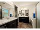 Bright bathroom with dual sinks, white countertops, dark wood cabinets, and a separate soaking tub and shower at 10635 W Eucalyptus Rd, Peoria, AZ 85383