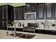 Modern kitchen features black cabinets, stainless steel appliances, and light countertops for a sleek design at 10635 W Eucalyptus Rd, Peoria, AZ 85383