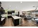 Open concept kitchen and living area with a large island, dark cabinets, and stainless steel appliances at 10635 W Eucalyptus Rd, Peoria, AZ 85383