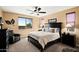 Comfortable bedroom with large window, dark wood furniture, neutral walls, and carpeted flooring at 10635 W Eucalyptus Rd, Peoria, AZ 85383