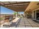 Spacious patio with travertine tile, water feature, outdoor seating, grill, and mountain views at 10635 W Eucalyptus Rd, Peoria, AZ 85383