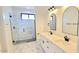 Modern bathroom featuring double vanities, marble floors and shower, and sleek black hardware at 11142 E Copper Dust Trl, Florence, AZ 85132
