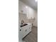 Well-lit laundry room boasts white cabinetry, a stainless sink, and sleek floors for functional space and style at 11142 E Copper Dust Trl, Florence, AZ 85132