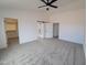 Spacious main bedroom with neutral carpet, a modern ceiling fan, and an en suite bathroom at 11142 E Copper Dust Trl, Florence, AZ 85132